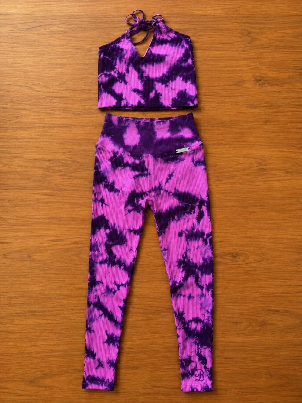 Bombshell Sportswear matching activewear set in a vibrant purple/pink tie-dye ri